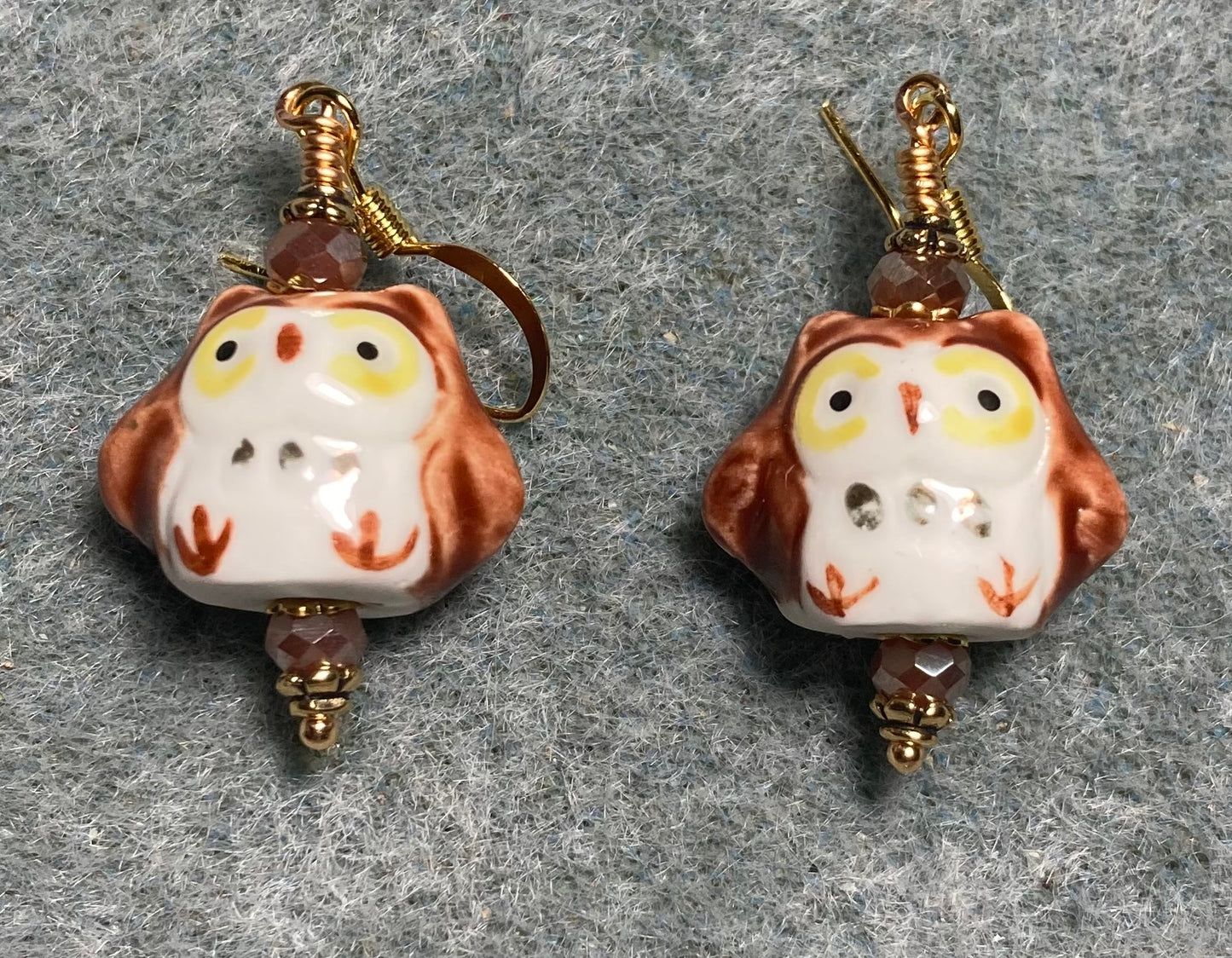 Brown, yellow, and white ceramic spotted owl bead earrings adorned with brown Chinese crystal beads.