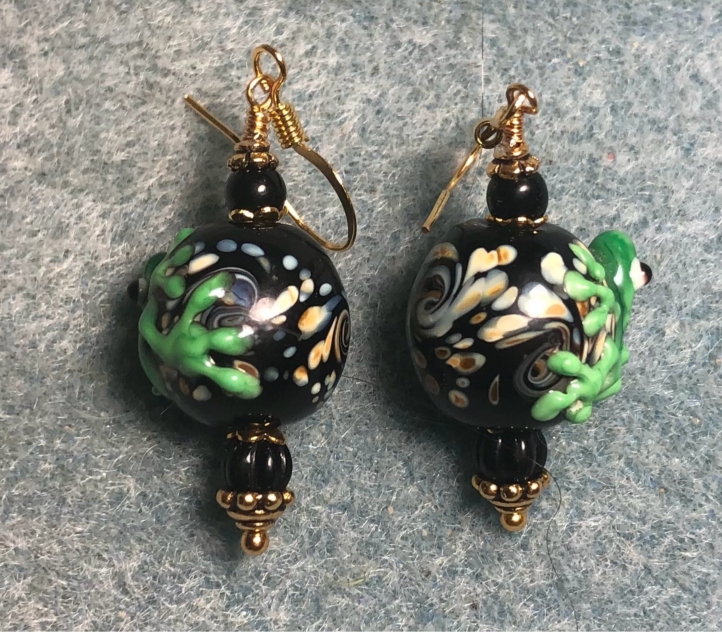 Black and bright green lamp work frog bead earrings adorned with black Czech glass beads.