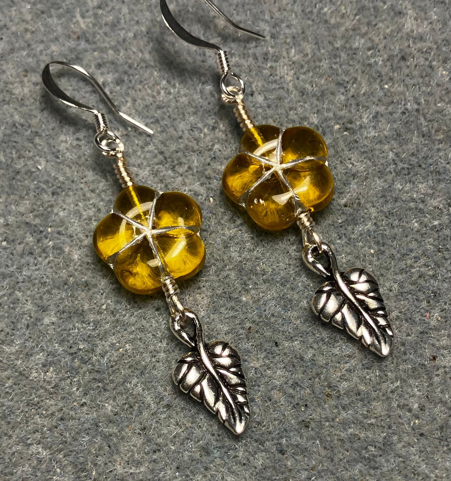 Yellow (with silver inlay) Czech glass puffy flower bead earrings adorned with silver Tierracast leaf charms.