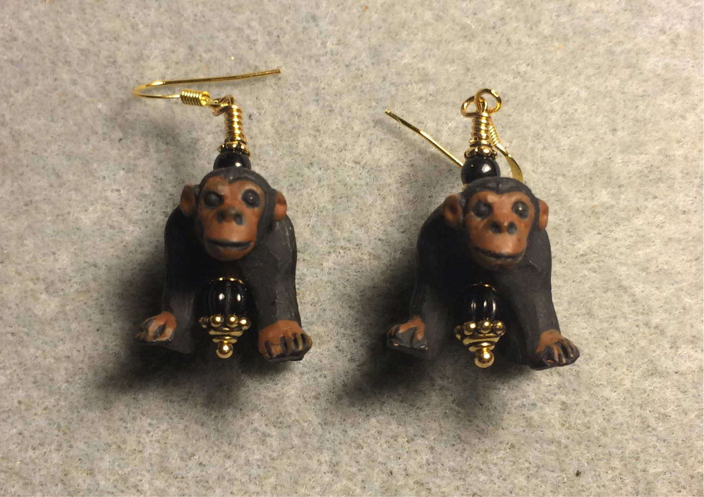 Large black and brown ceramic chimpanzee bead earrings adorned with black Czech glass beads.