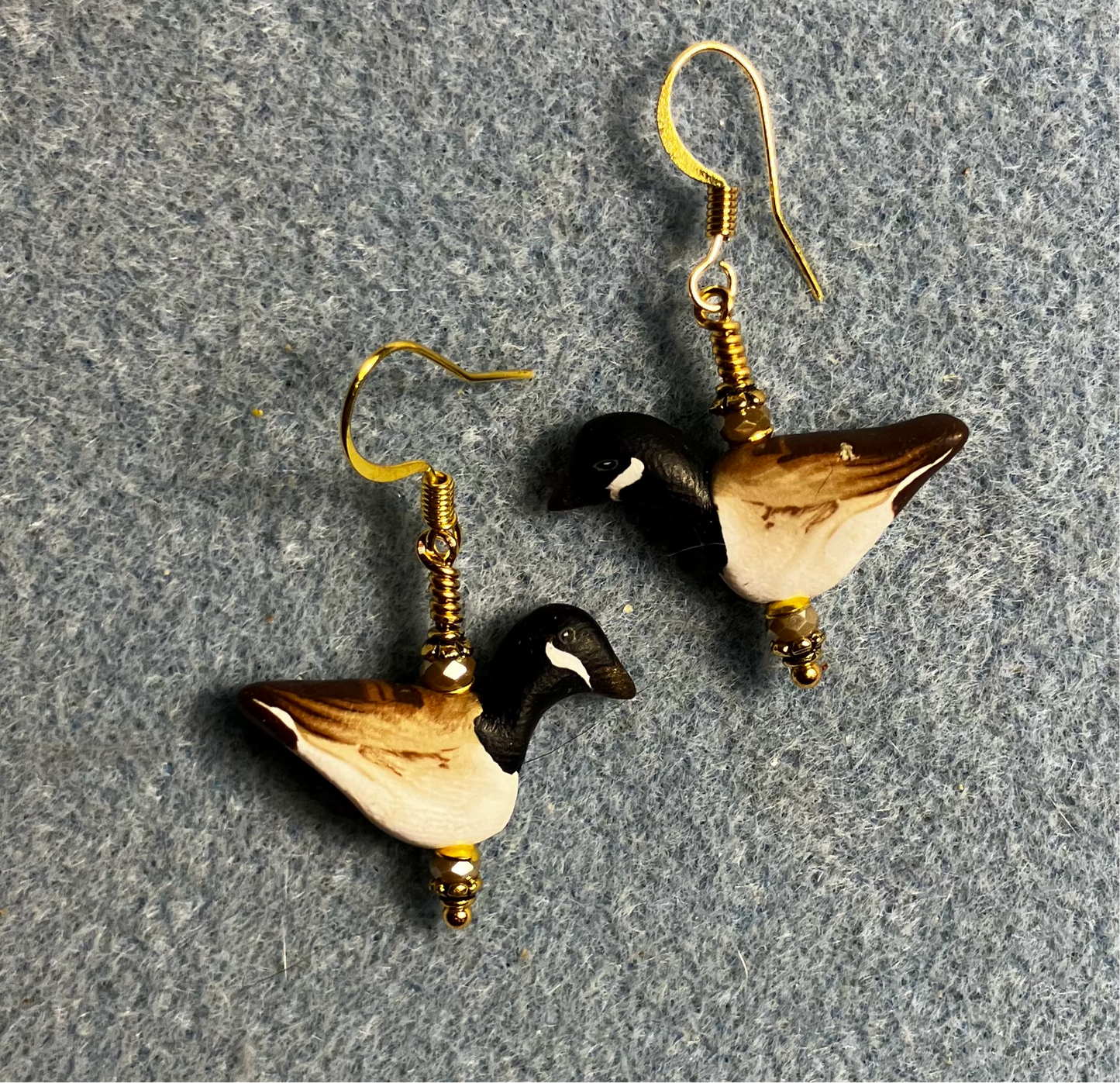Black, brown, and tan polymer clay goose bead earrings adorned with tan Chinese crystal beads.