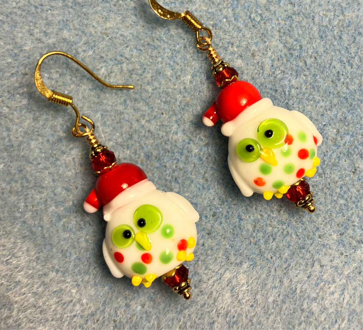 Red, green, and yellow lamp work Santa owl bead earrings adorned with red Chinese crystal beads.