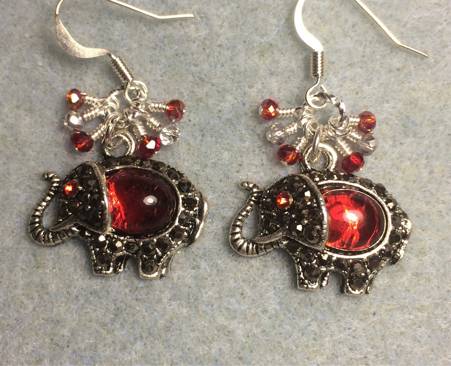 Ornate silver and red rhinestone elephant charm earrings adorned with small dangling red and silver Chinese crystal beads.