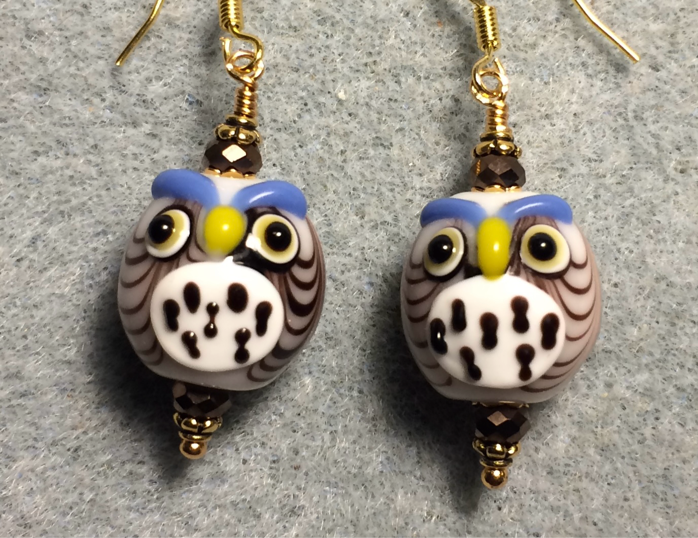 Brown and white lamp work spotted owl bead earrings adorned with brown Chinese crystal beads.