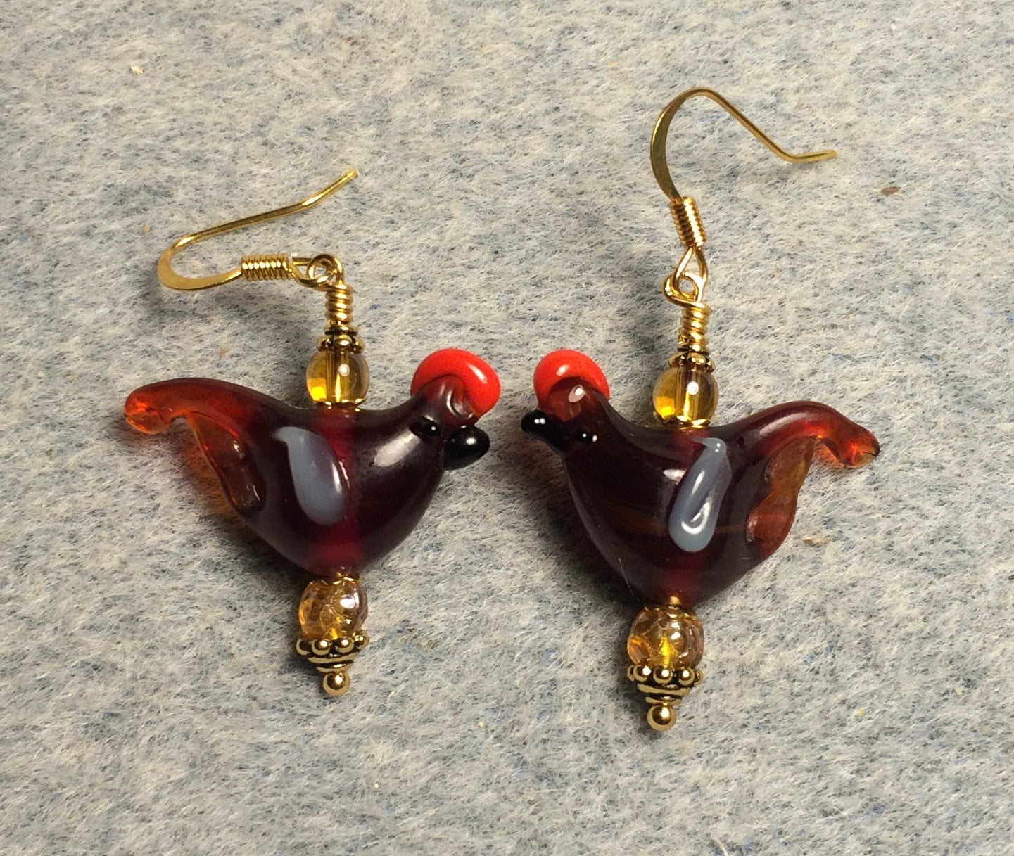 Translucent dark amber lamp work songbird bead earrings adorned with amber Czech glass beads.