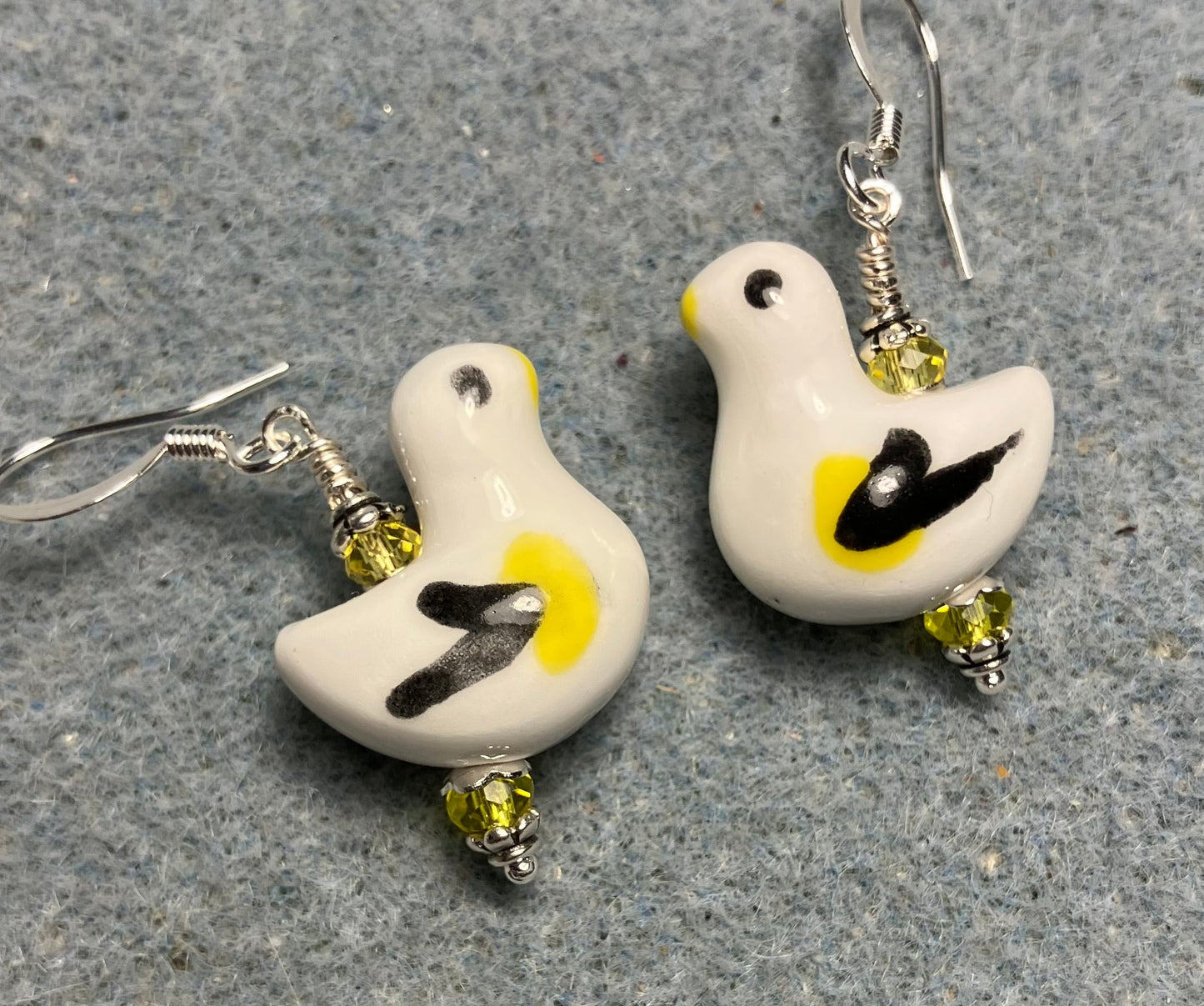 White, black, and yellow ceramic duck bead earrings adorned with yellow Chinese crystal beads.
