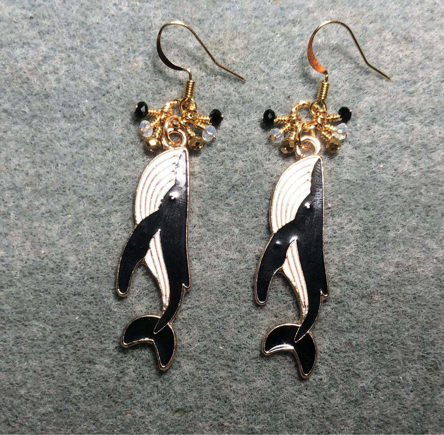 Long black and white enamel whale charm earrings adorned with tiny dangling black, white,and gold Chinese crystal beads.