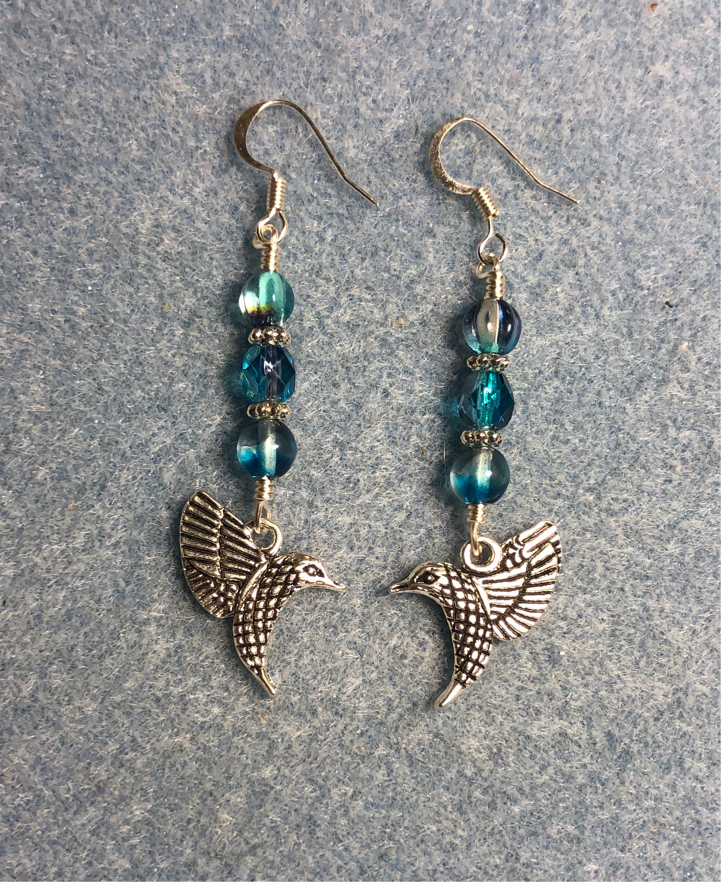 Silver hummingbird charm earrings adorned with turquoise Czech glass beads