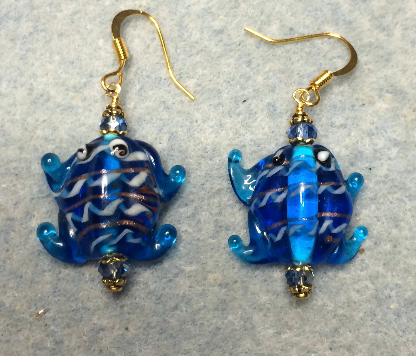 Turquoise blue lamp work frog bead earrings adorned with turquoise Chinese crystal beads.