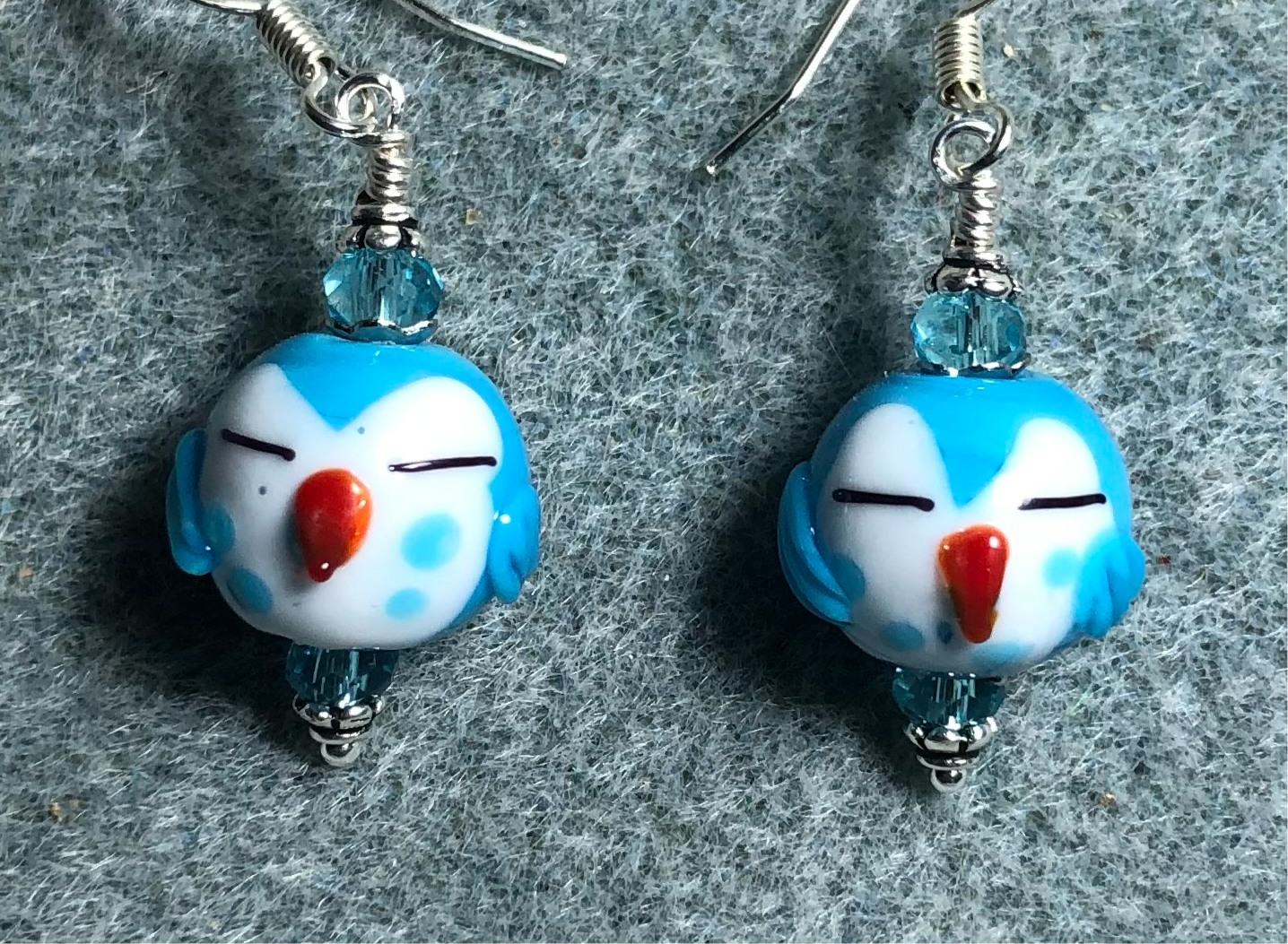 Small turquoise and white lamp work sleepy owl bead earrings adorned with turquoise Chinese crystal beads.