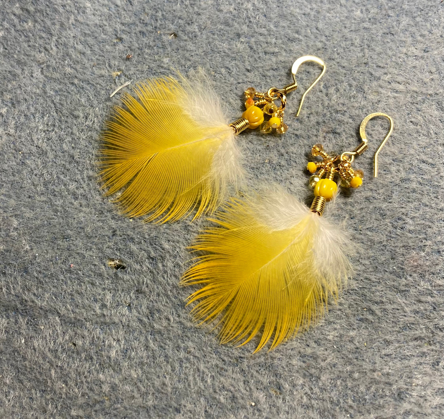 Small amber yellow macaw feather earrings adorned with tiny dangling amber and yellow Chinese crystal beads.