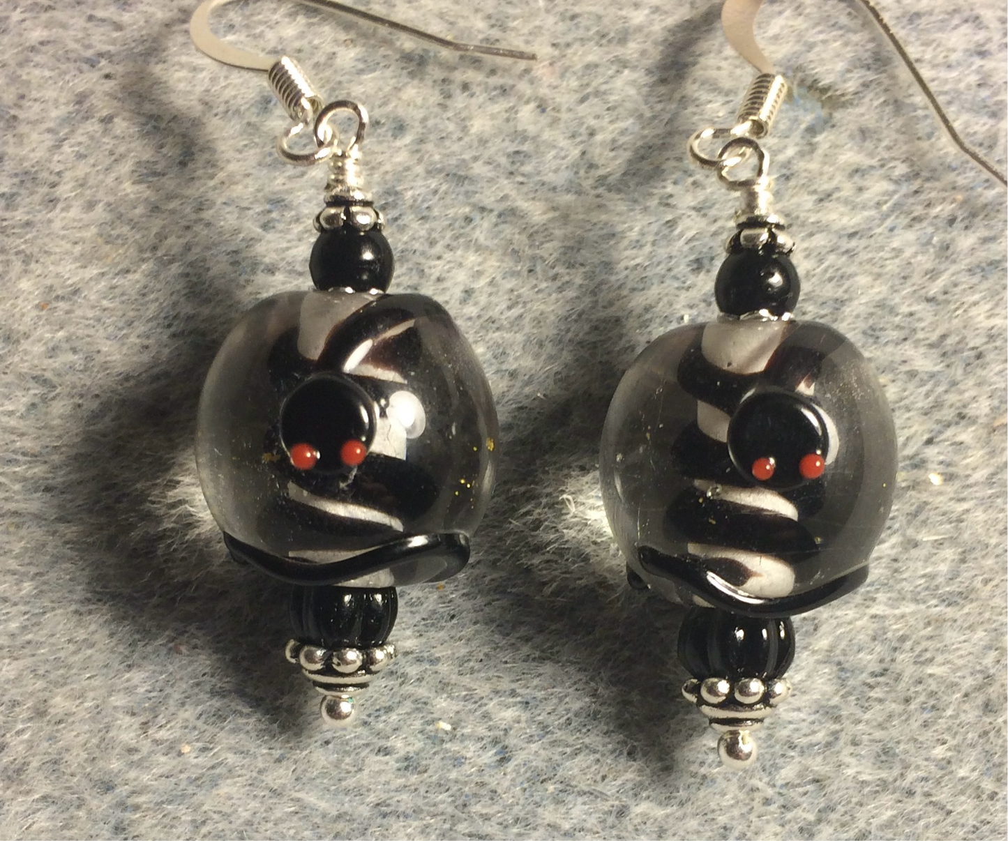 Clear and black lamp work snake bead earrings adorned with black Czech glass beads.