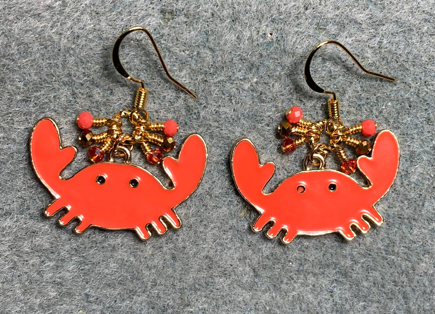 Large orange and gold enamel crab charm earrings adorned with tiny dangling orange and gold Chinese crystal beads.