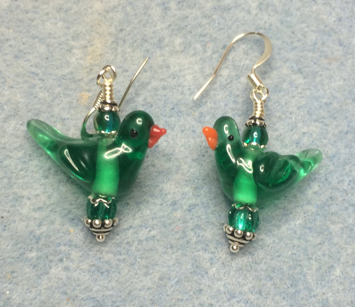 Translucent teal lamp work songbird bead earrings adorned with teal Czech glass beads.