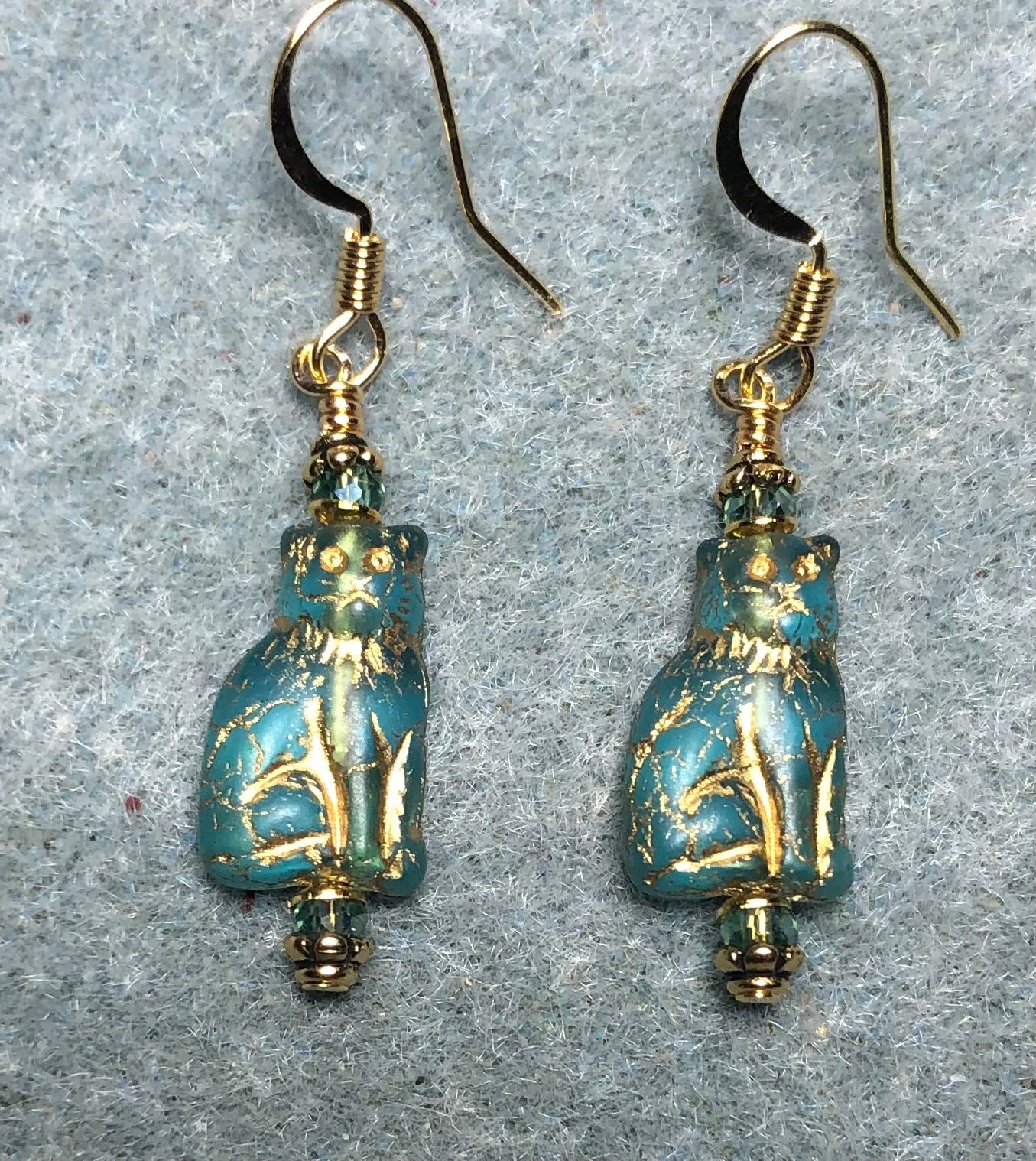Small turquoise and gold Czech glass cat bead earrings adorned with turquoise Chinese crystal beads.