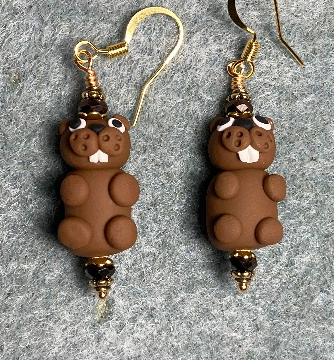 Brown and white polymer clay beaver bead earrings adorned with brown Chinese crystal beads.