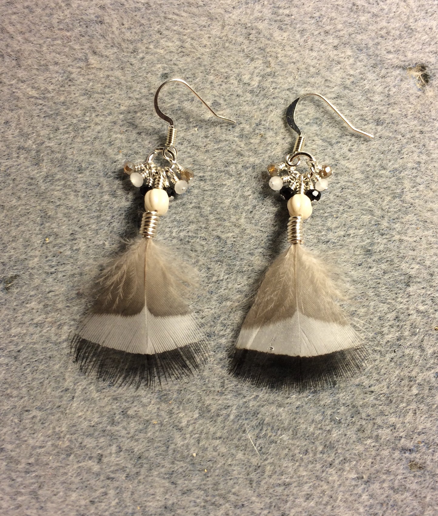 White and tan striped duck feather earrings adorned with white Czech glass melon beads and tiny dangling white, black, and tan Chinese crystal beads.
