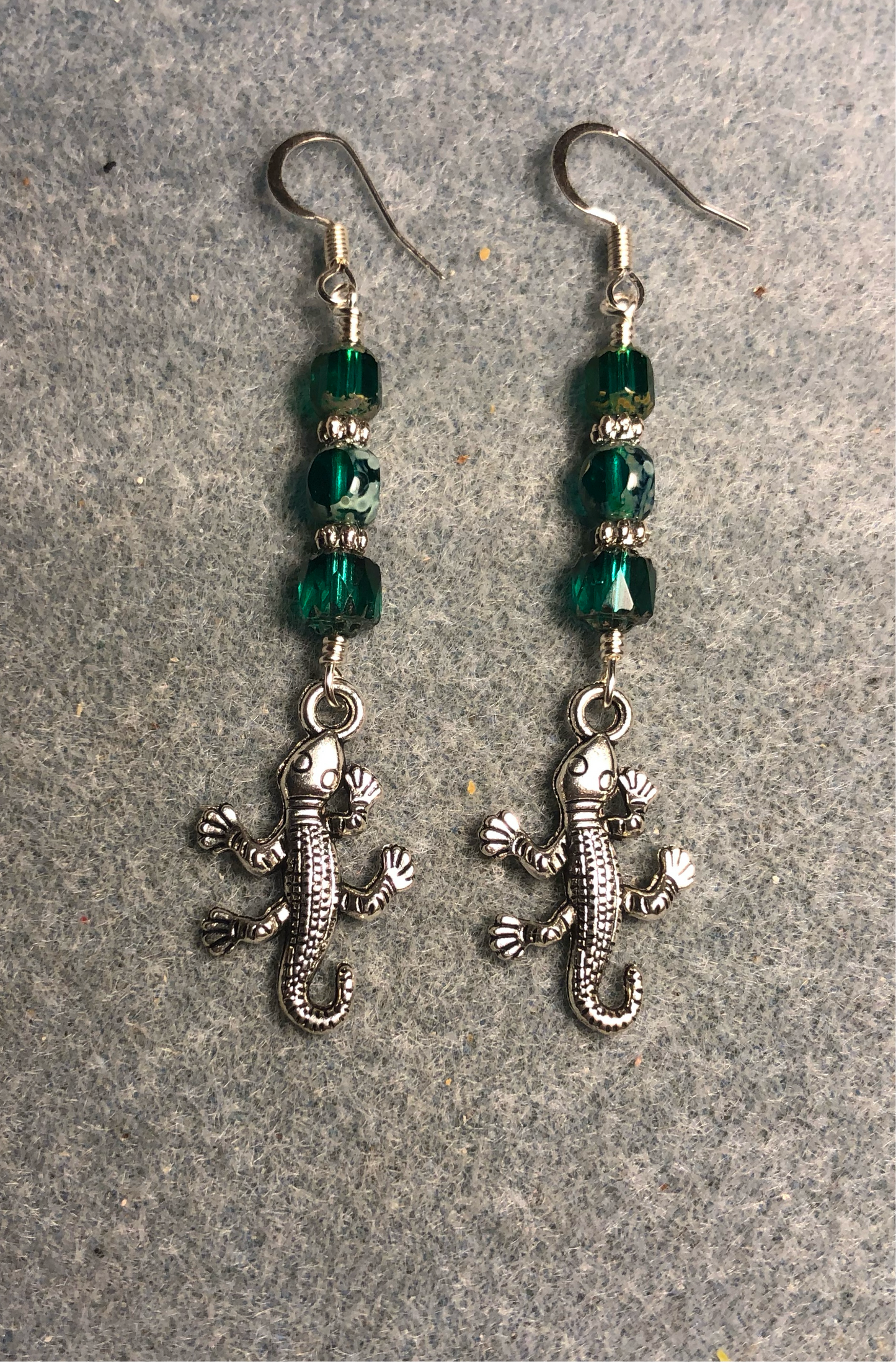 Silver lizard charm earrings adorned with teal Czech glass beads.