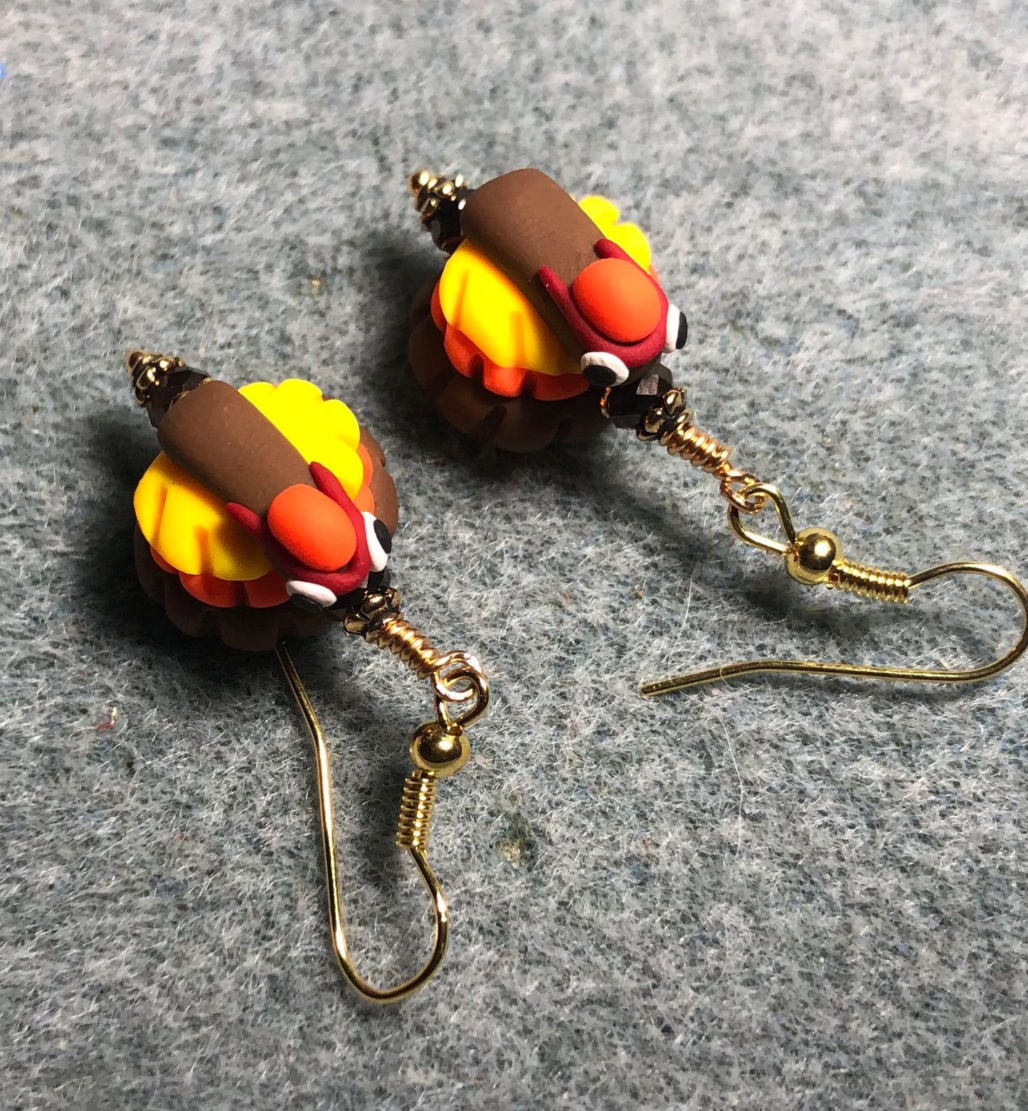 Brown, yellow, and orange polymer clay turkey bead earrings adorned with brown Chinese crystal beads.