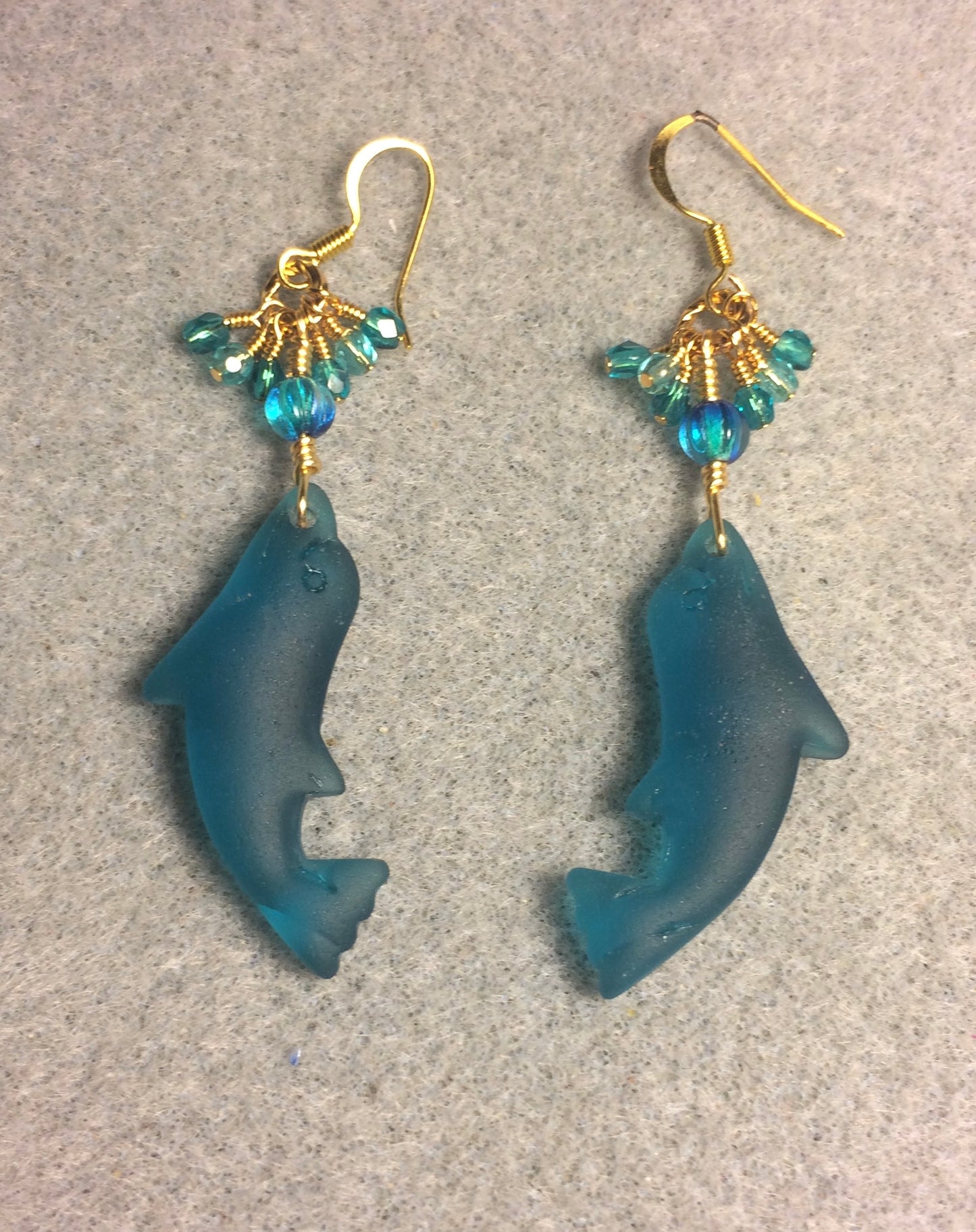 Dark turquoise sea glass dolphin pendant bead earrings adorned with dark turquoise Czech glass beads and tiny dangling dark turquoise Czech glass beads.