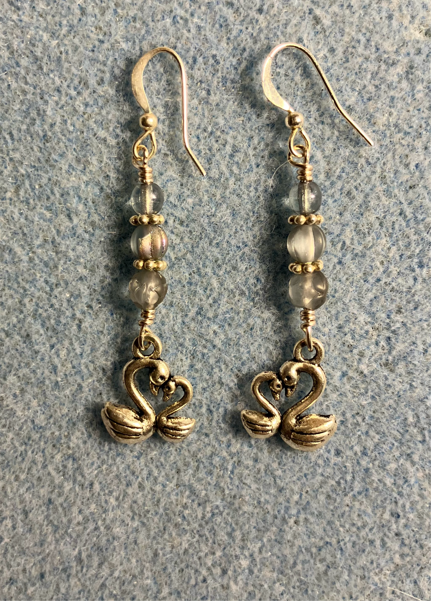 Small silver swan charm earrings adorned with small light blue Czech glass beads