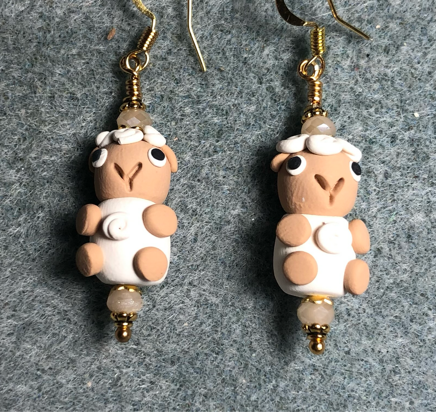 Tan and white polymer clay sheep bead earrings adorned with tan Chinese crystal beads.