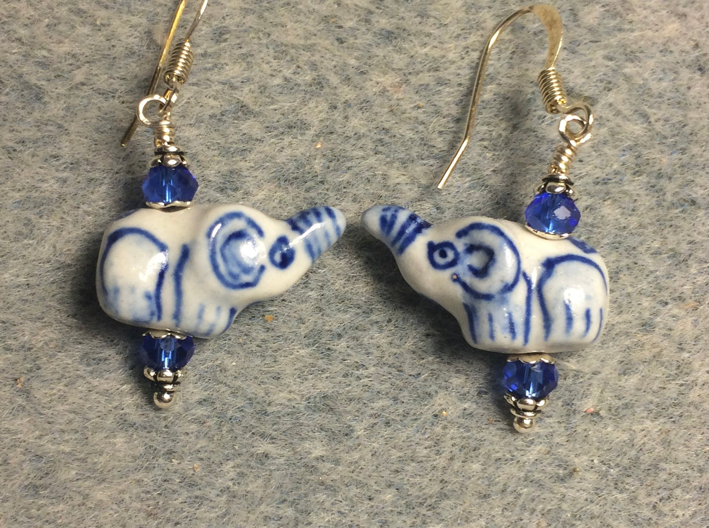 Small white and blue ceramic elephant bead earrings adorned with blue Chinese crystal beads.