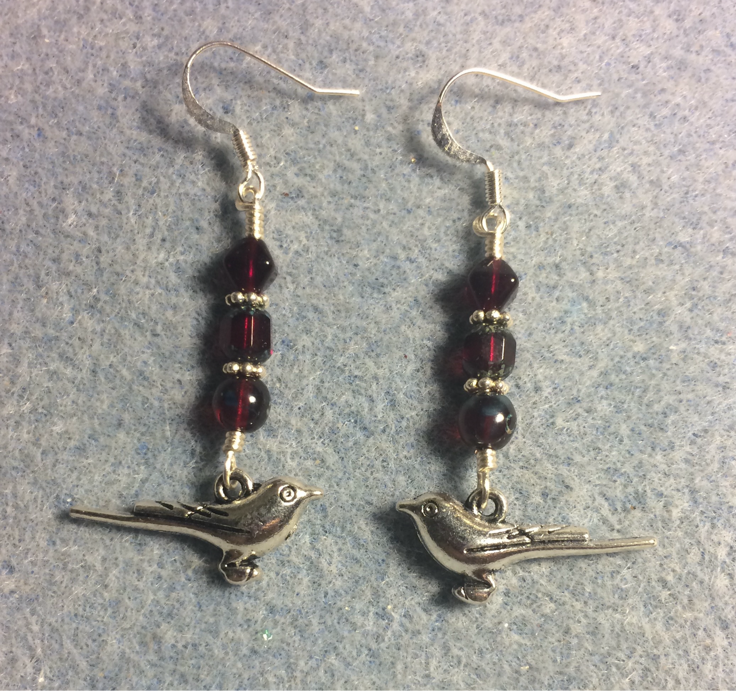 Silver bird charm earrings adorned with dark ruby red Czech glass beads