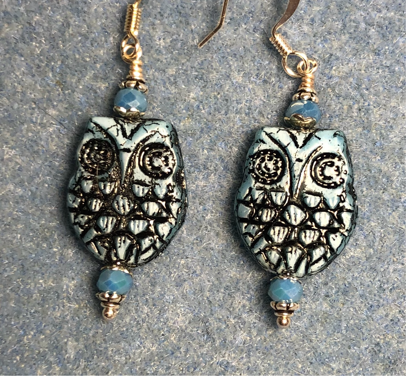 Light blue (with black wash) Czech glass owl bead earrings adorned with light blue Chinese crystal beads.