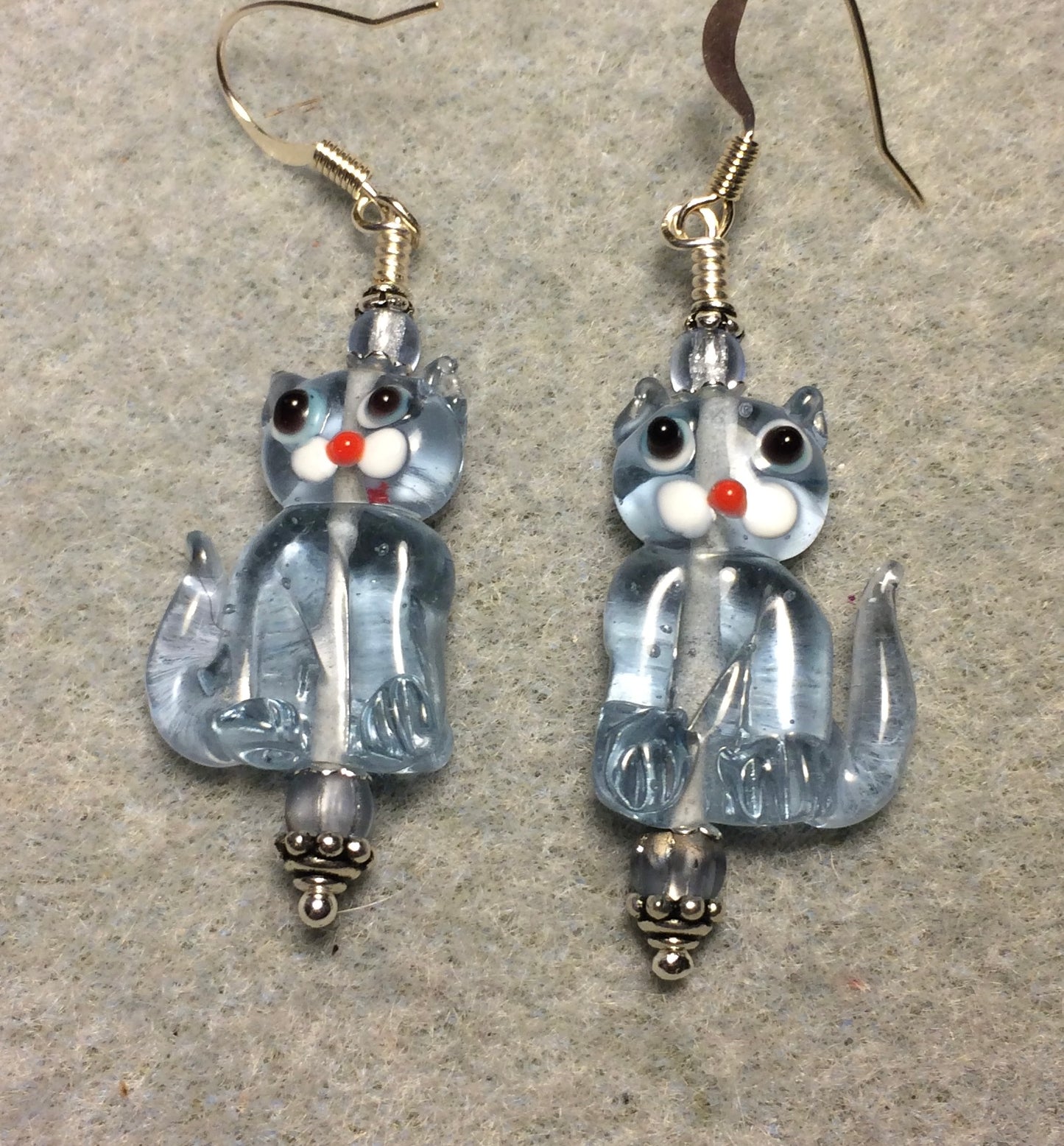 Translucent light blue lamp work cat bead earrings adorned with light blue Czech glass beads.