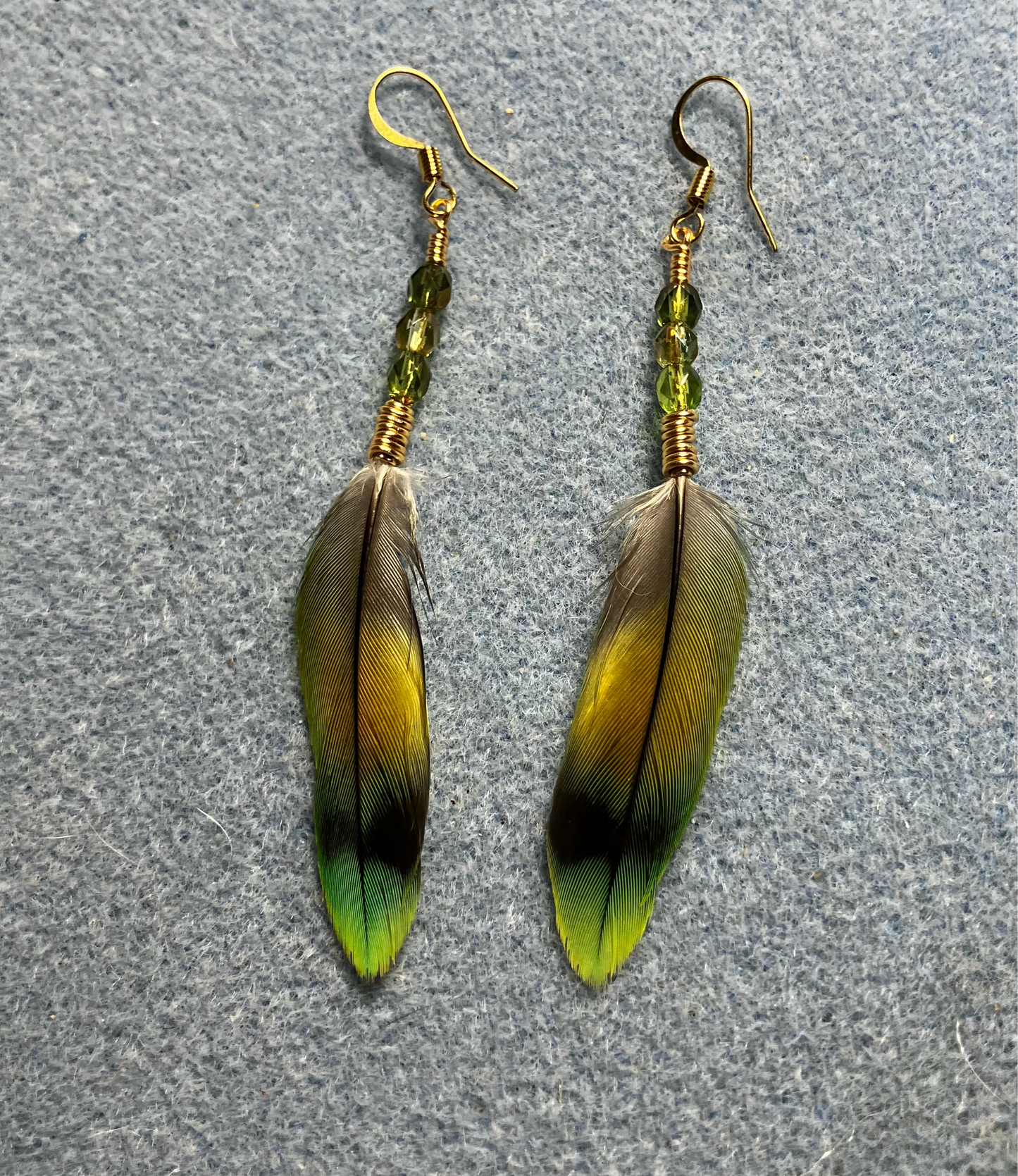 Dark green and olive green lovebird feather earrings adorned with small olive green Czech glass beads.