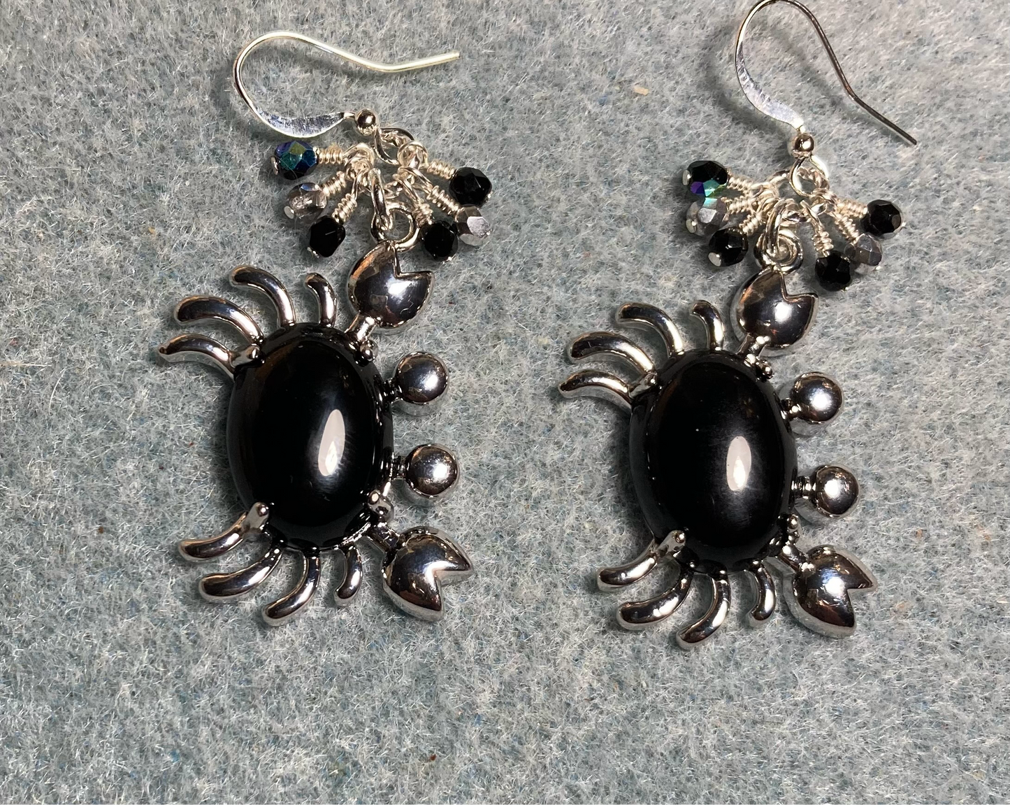 Silver and black onyx gemstone crab charm earrings adorned with small dangling black and silver Czech glass beads.