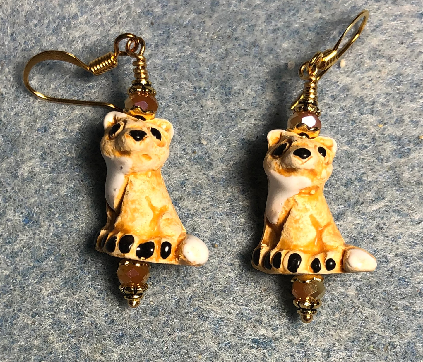 Small beige and white ceramic fox bead earrings adorned beige Chinese crystal beads.