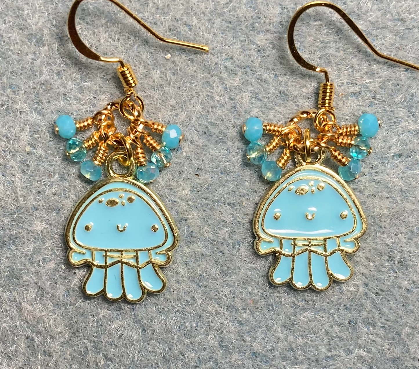 Turquoise and gold enamel jellyfish charm earrings adorned with tiny dangling turquoise Chinese crystal beads.