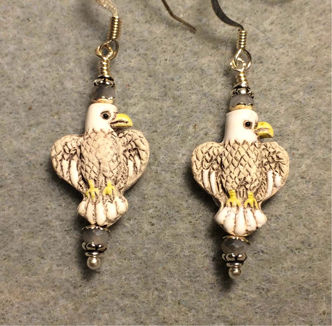 Small gray, white, and yellow ceramic flying eagle bead earrings adorned with gray white Chinese crystal beads.