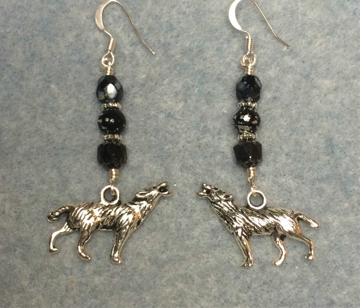 Silver howling wolf charm earrings adorned with black Czech glass beads.