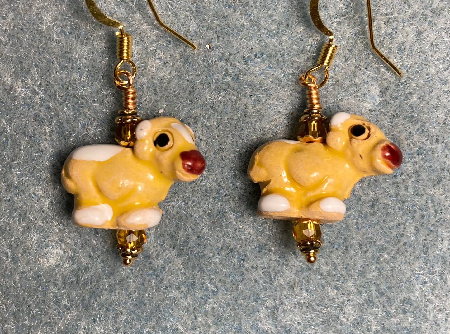 Small amber and white ceramic cow bead earrings adorned with small amber Chinese crystal beads.