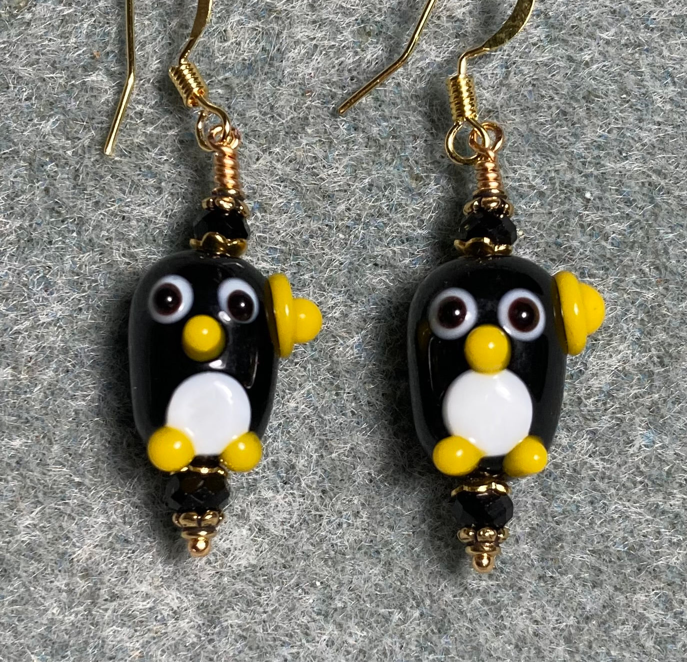 Black, white, and yellow lamp work owl bead earrings adorned with black Chinese crystal beads.