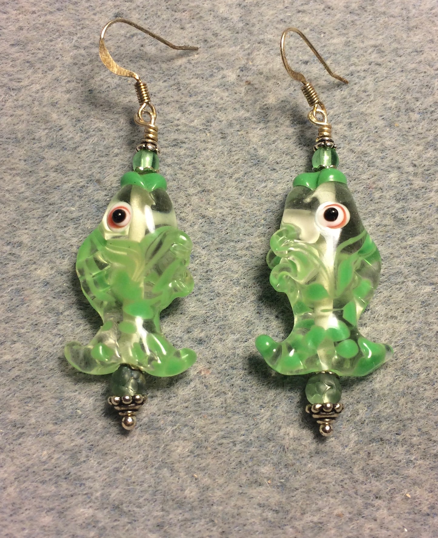 Light green and clear lamp work fish bead earrings adorned with light green Czech glass beads.