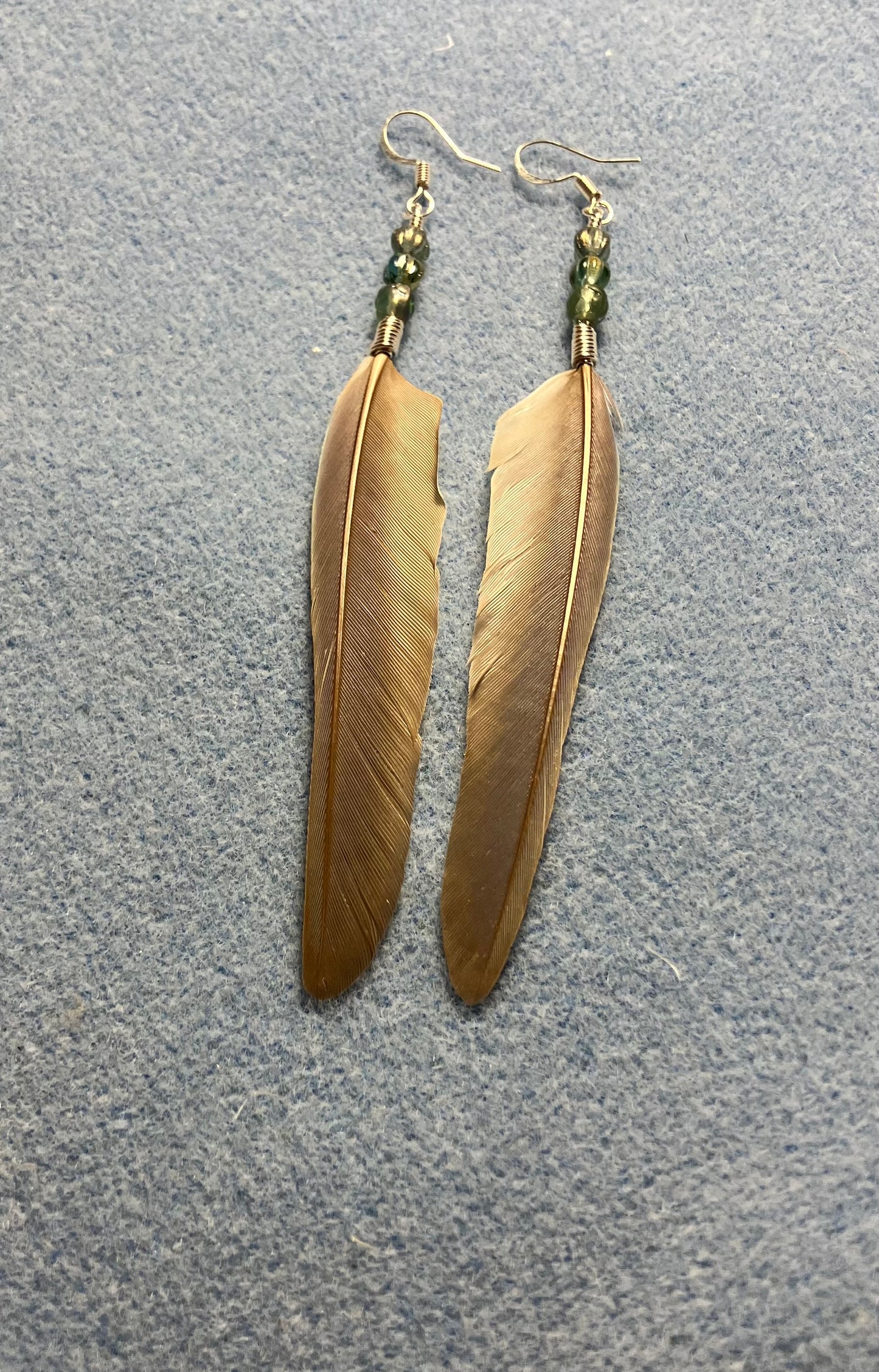 Bluish gray green cheeked conure feather earrings adorned with small light green Czech glass beads.