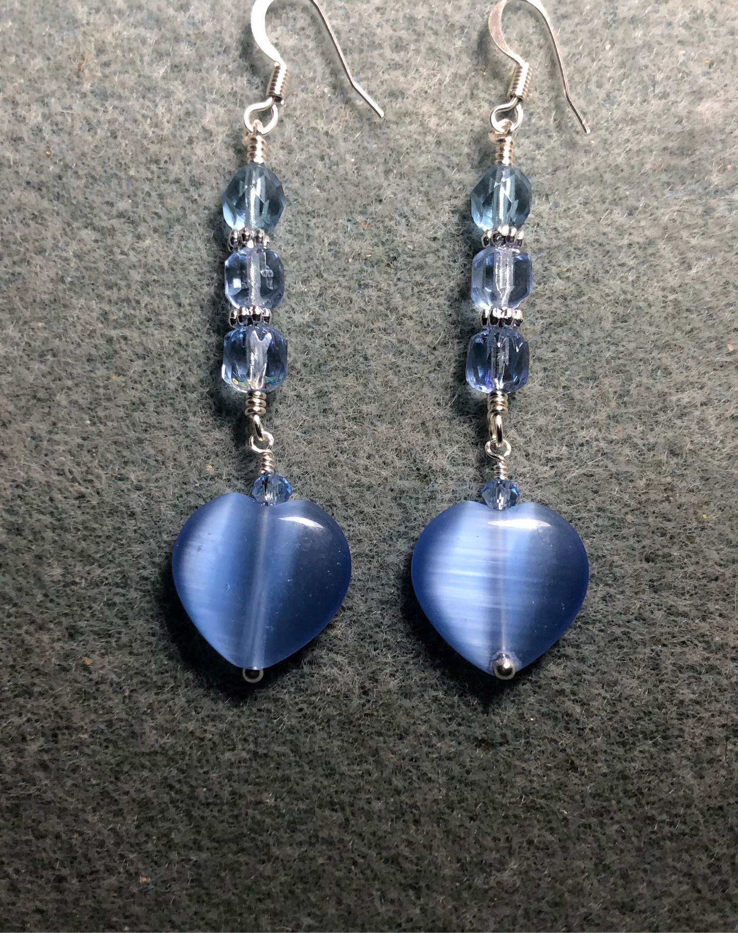 Light blue fiber optic (cat’s eye) Czech glass heart bead earrings adorned with light blue Czech glass beads.