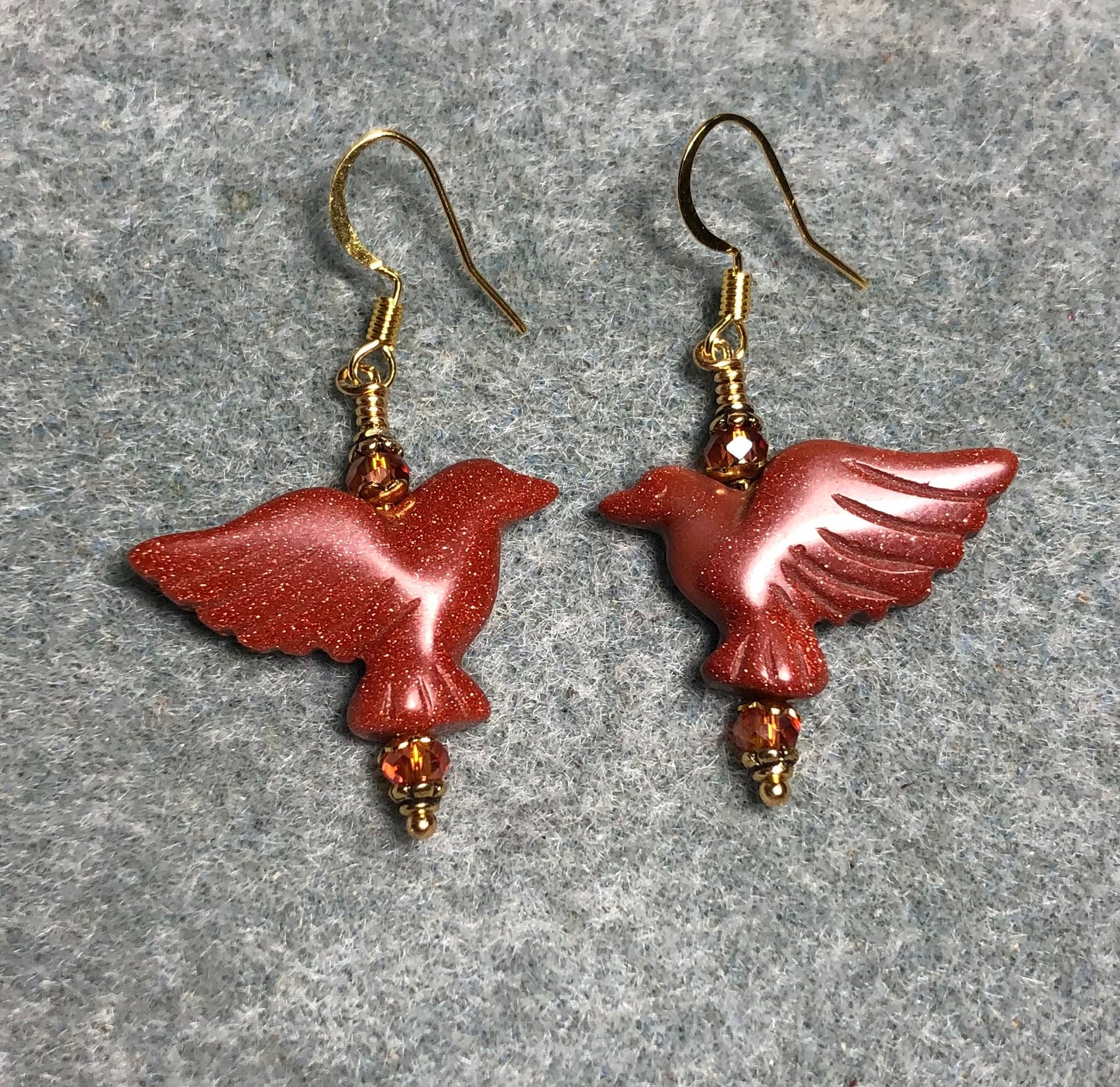 Orange goldstone gemstone flying eagle bead earrings adorned with sparkly orange Chinese crystal beads.