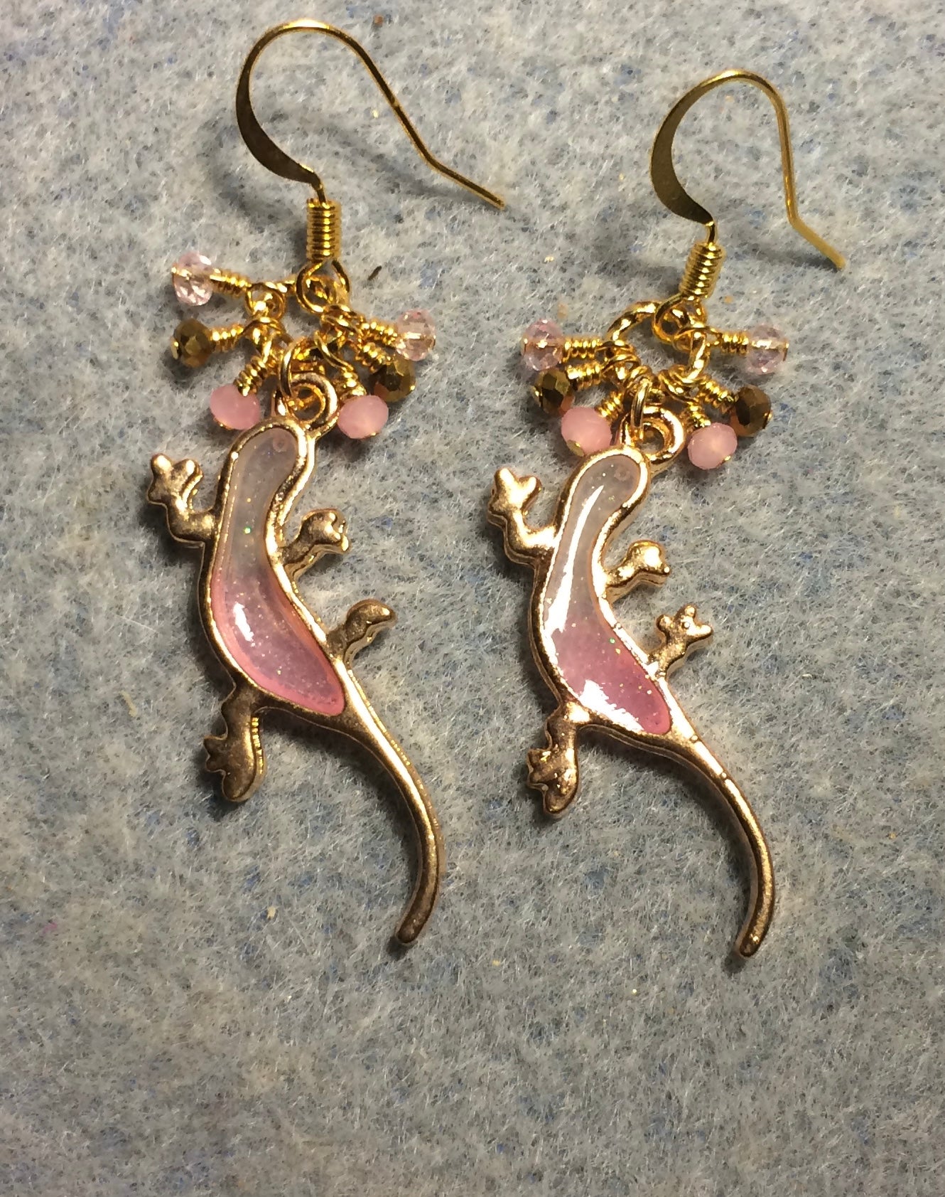 Pink and gold resin lizard charm earrings adorned with tiny dangling pink and gold Chinese crystal beads.