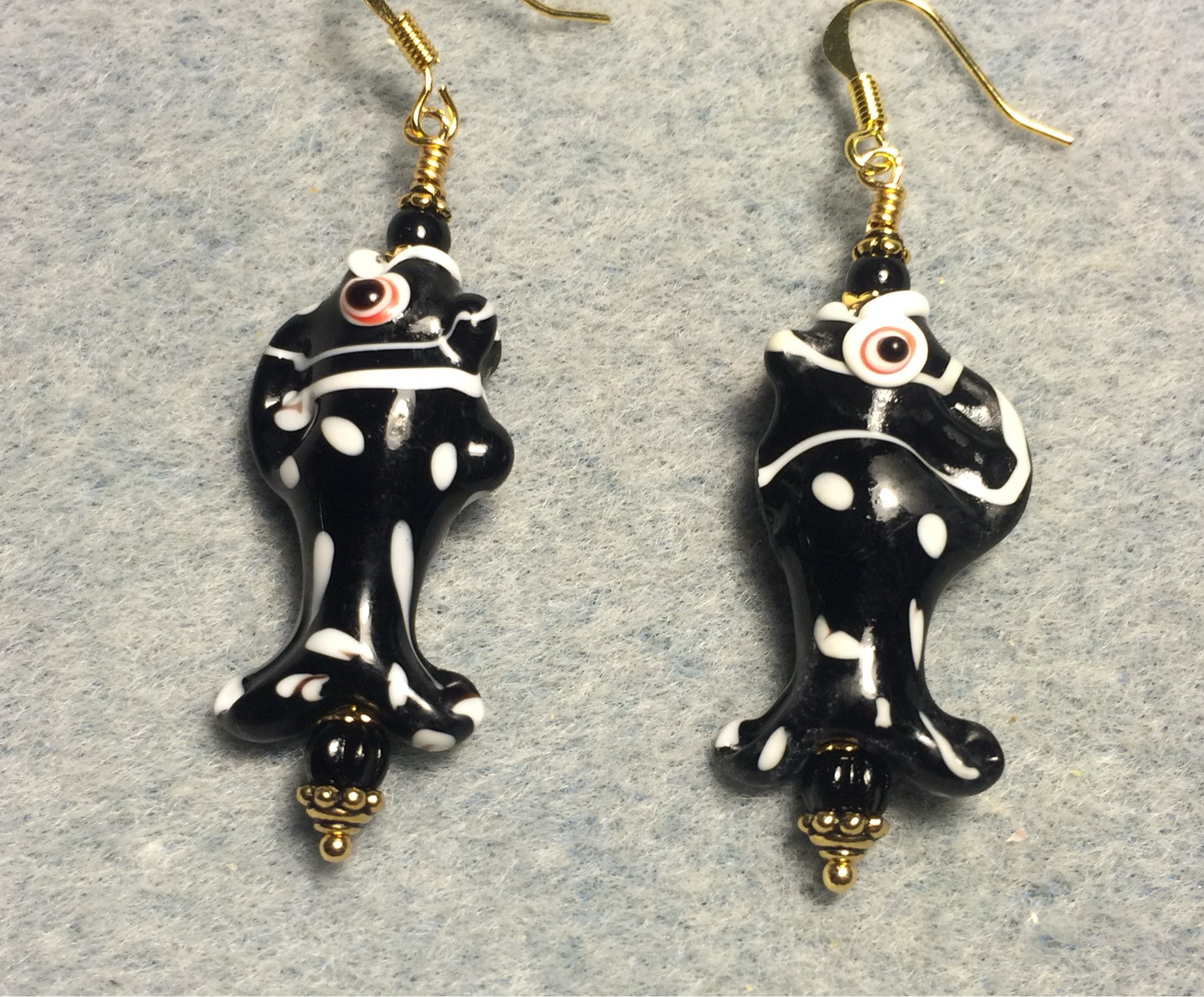 Black and white lamp work spotted fish bead earrings adorned with black Czech glass beads.