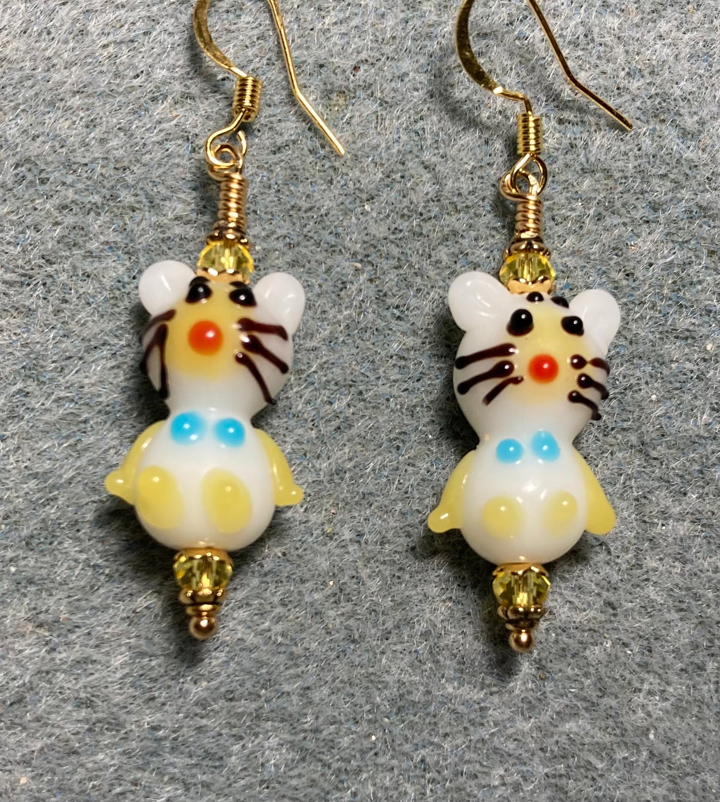 Small white and yellow lamp work cat bead earrings adorned with yellow Chinese crystal beads.