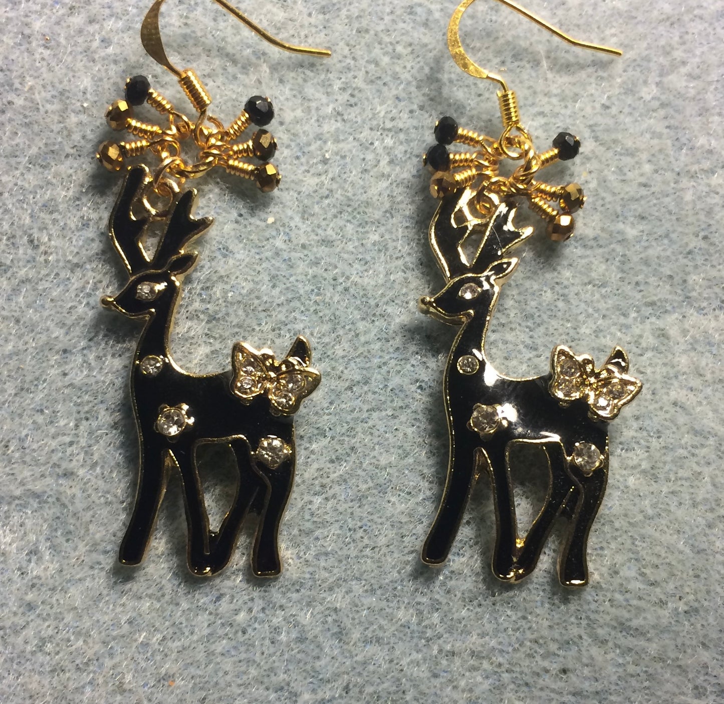 Large black and gold enamel and rhinestone deer charm earrings adorned with tiny dangling black and gold Chinese crystal beads.