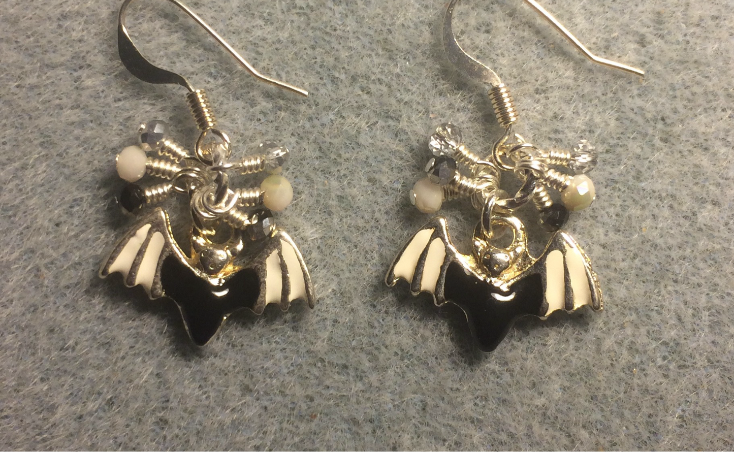 Black, white, and silver enamel bat charm earrings adorned with tiny dangling black, white, and silver Chinese crystal beads.