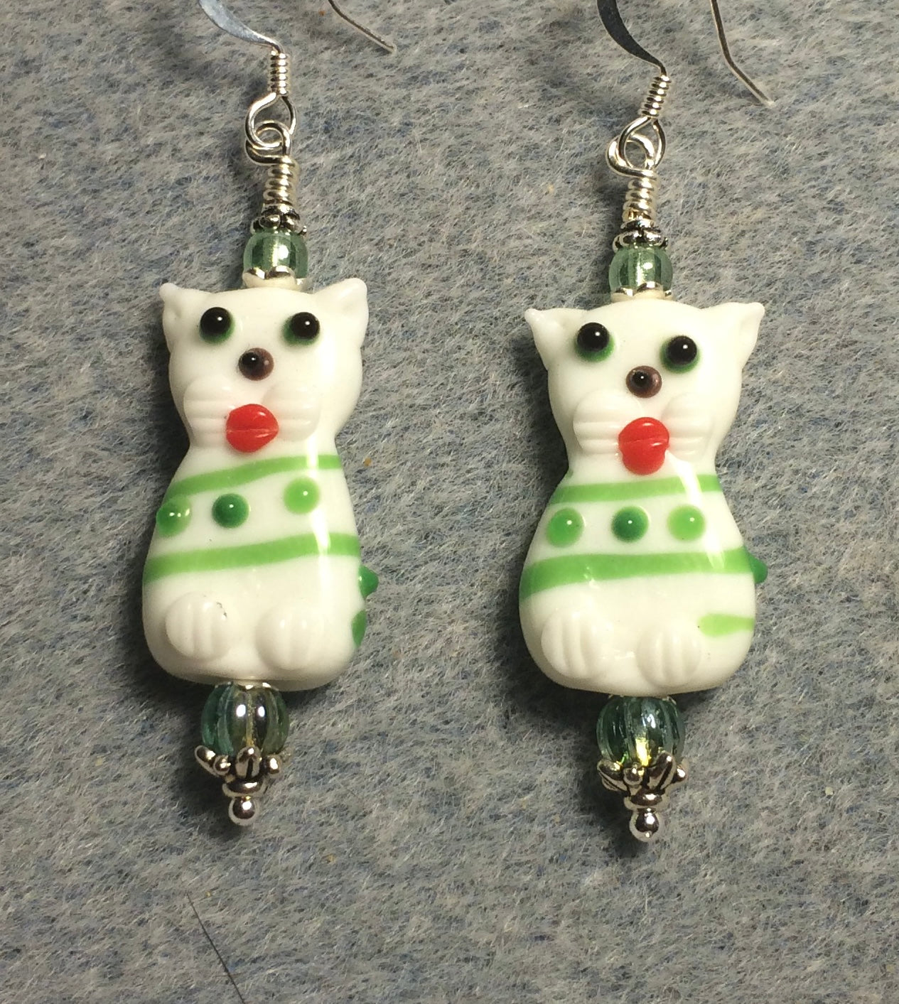 White, green, and orange lamp work cat bead earrings adorned with green Czech glass beads.