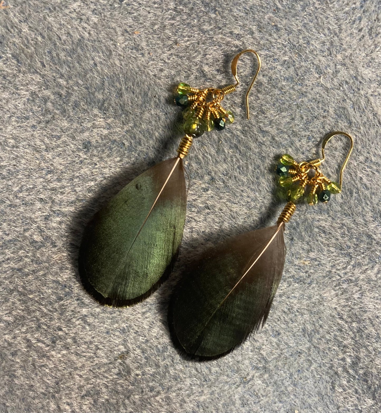 Iridescent green Lady Amherst pheasant feather earrings adorned with green Czech glass rosebud beads and small dangling green Czech glass beads.