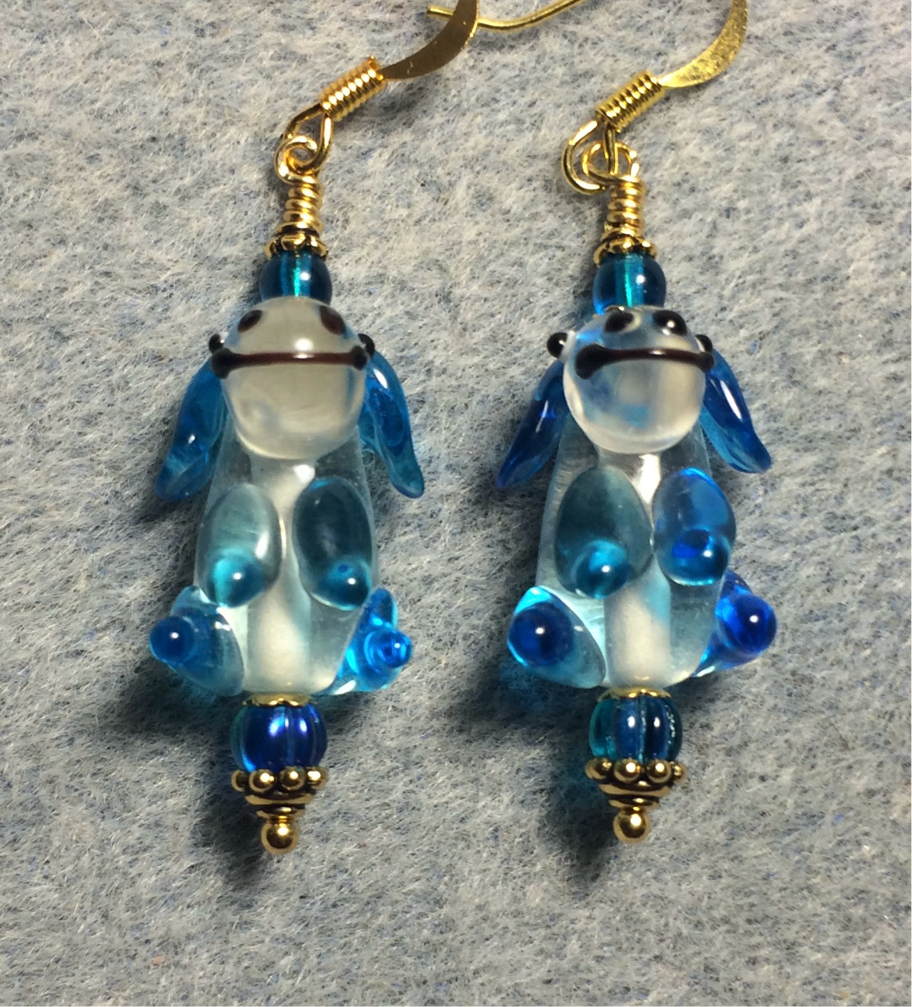 Turquoise and clear lamp work puppy dog bead earrings adorned with turquoise Czech glass beads.
